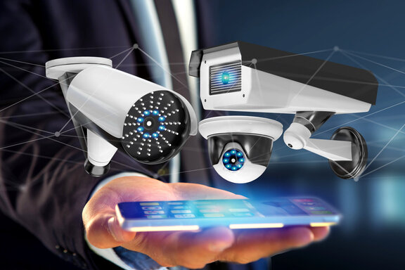 Businessman using a smartphone with a Security camera system and network connection - 3d rendering Videoueberwachung.jpeg
